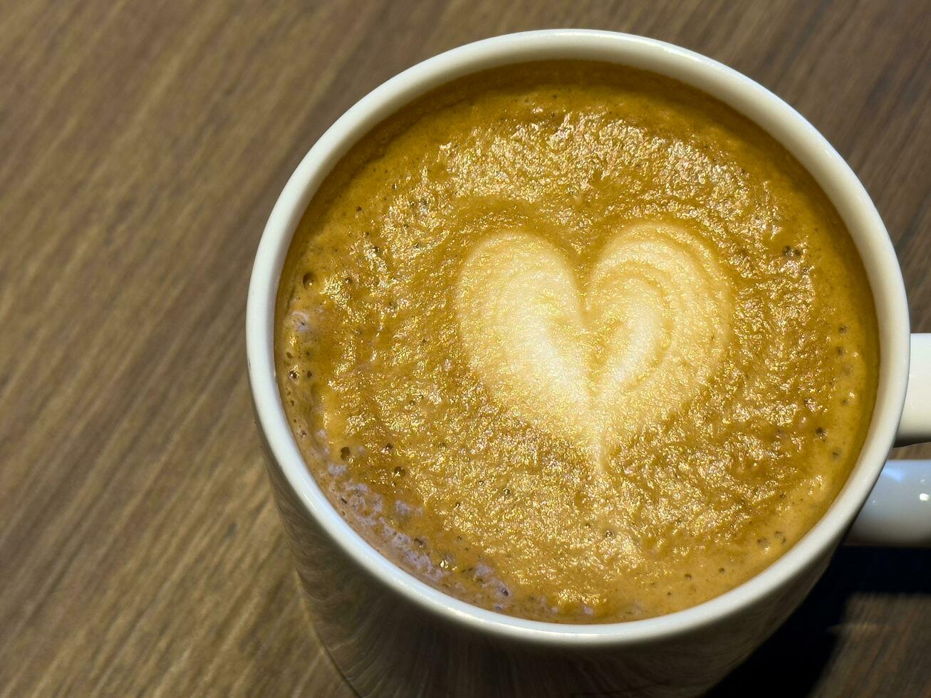 un latté con en forma de corazon Leche espuma en parte superior foto