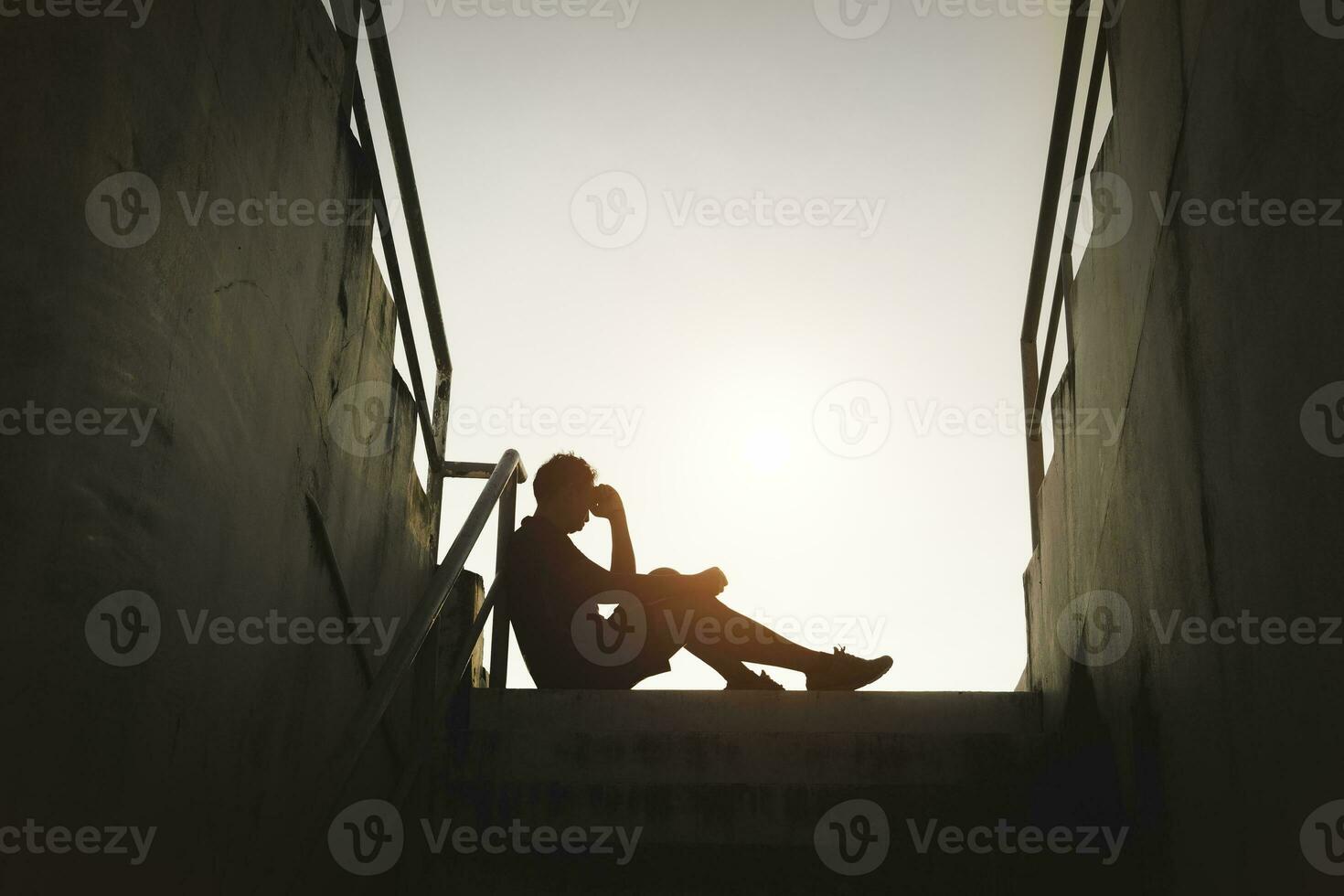 Silhouetted of sad photo. Lonely man sitting on the floor.He is unhappy and sad.He is depression.unlove,unhappy,fail.Photo concept for Disease and depression. photo