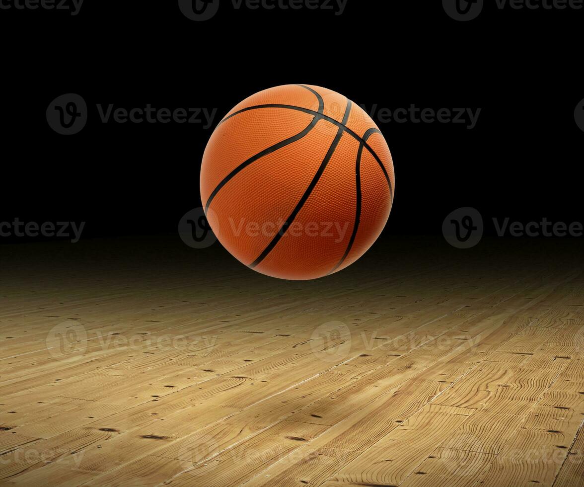 A basketball with a dark background on a hardwood gym floor photo