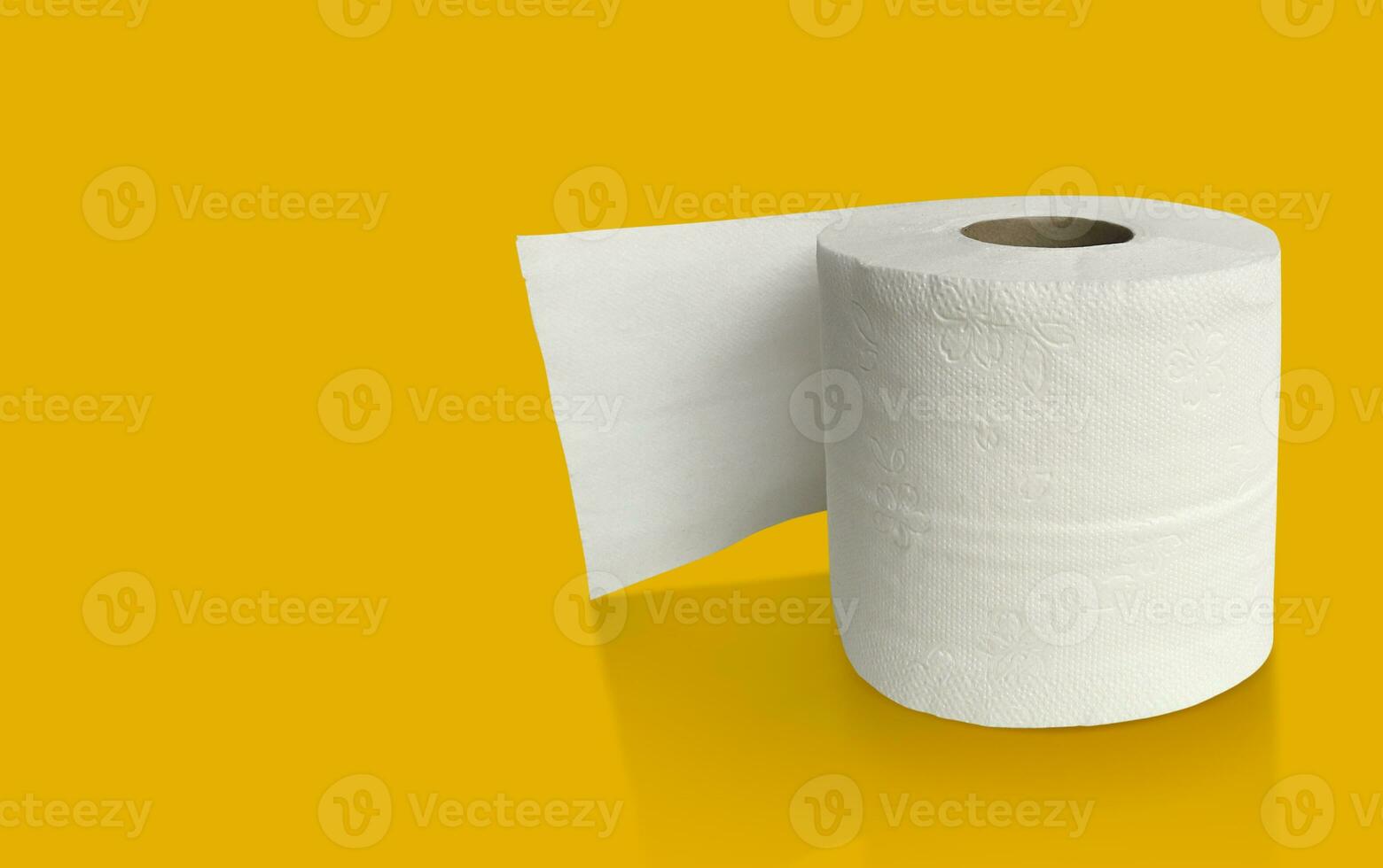 Roll of toilet paper on top on a yellow background for advertising photo