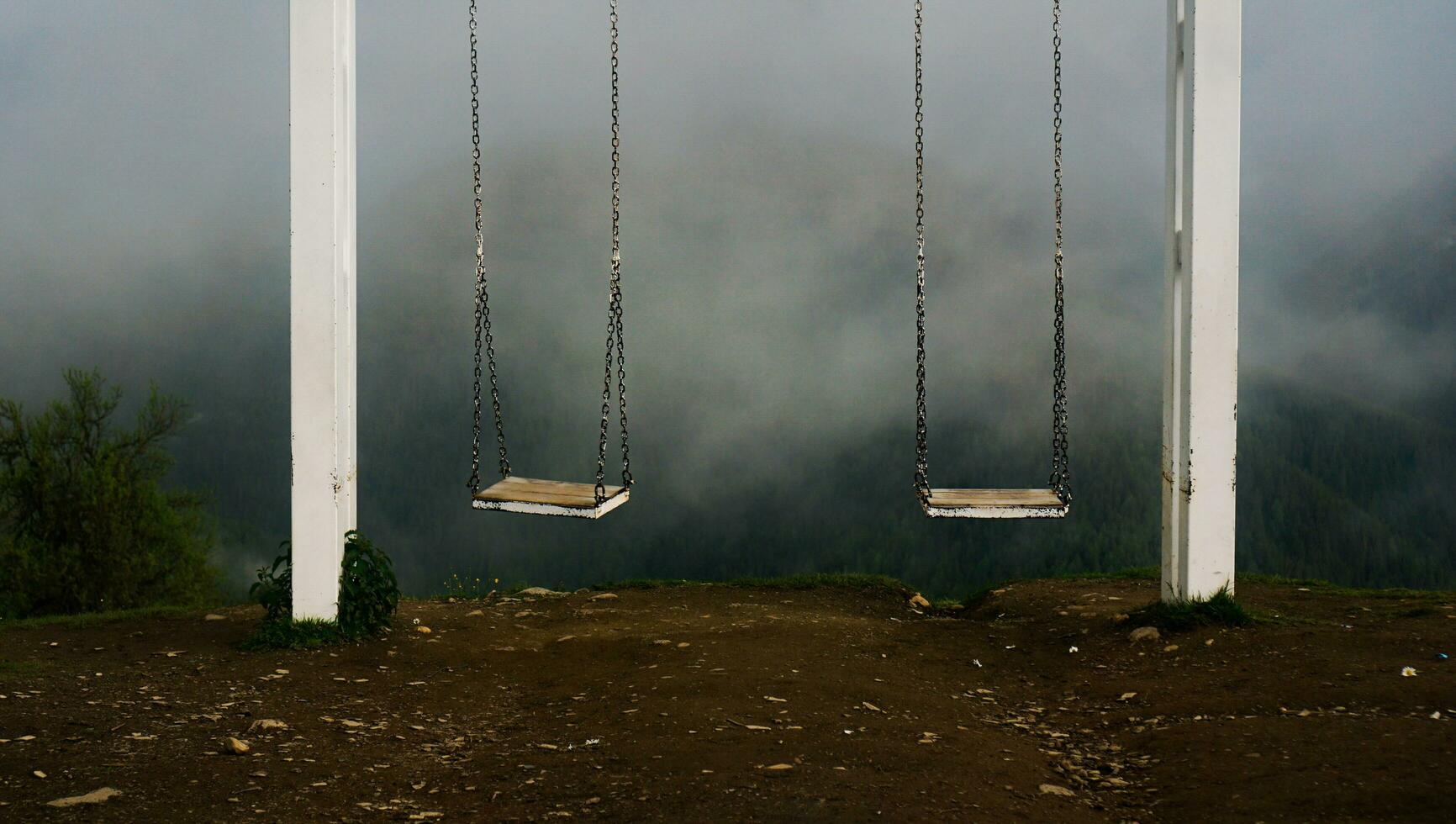 The sight of Svaneti - swing in mountains. Empty swing against foggy mountains photo