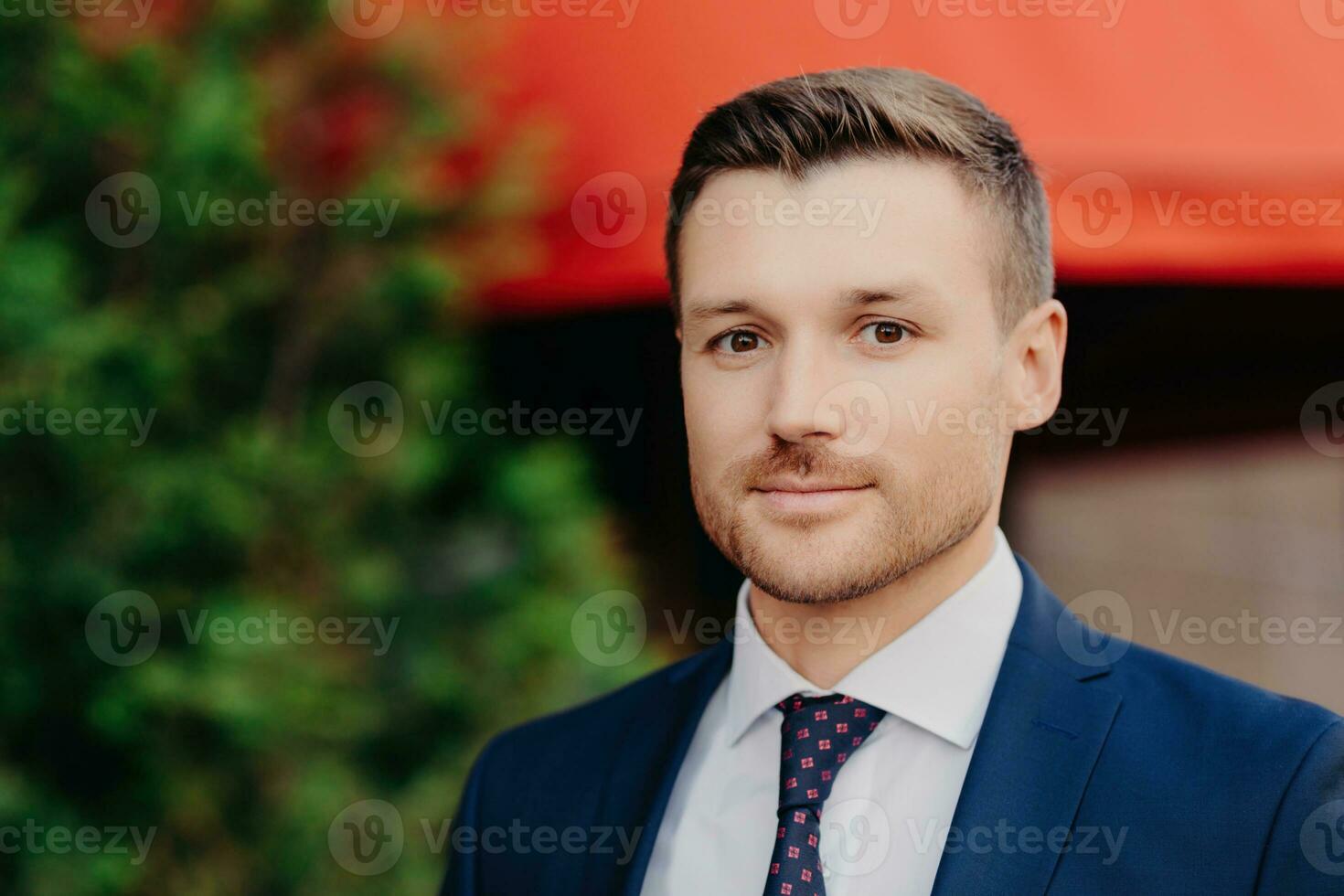 Attractive manager, confident gaze, formal attire poses outside, business meeting with partners abroad. photo