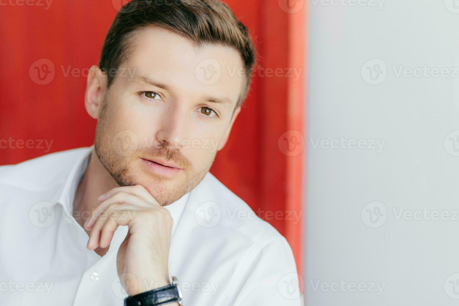 Confident man, white shirt, healthy skin, listens, redwhite background for your ad promo photo