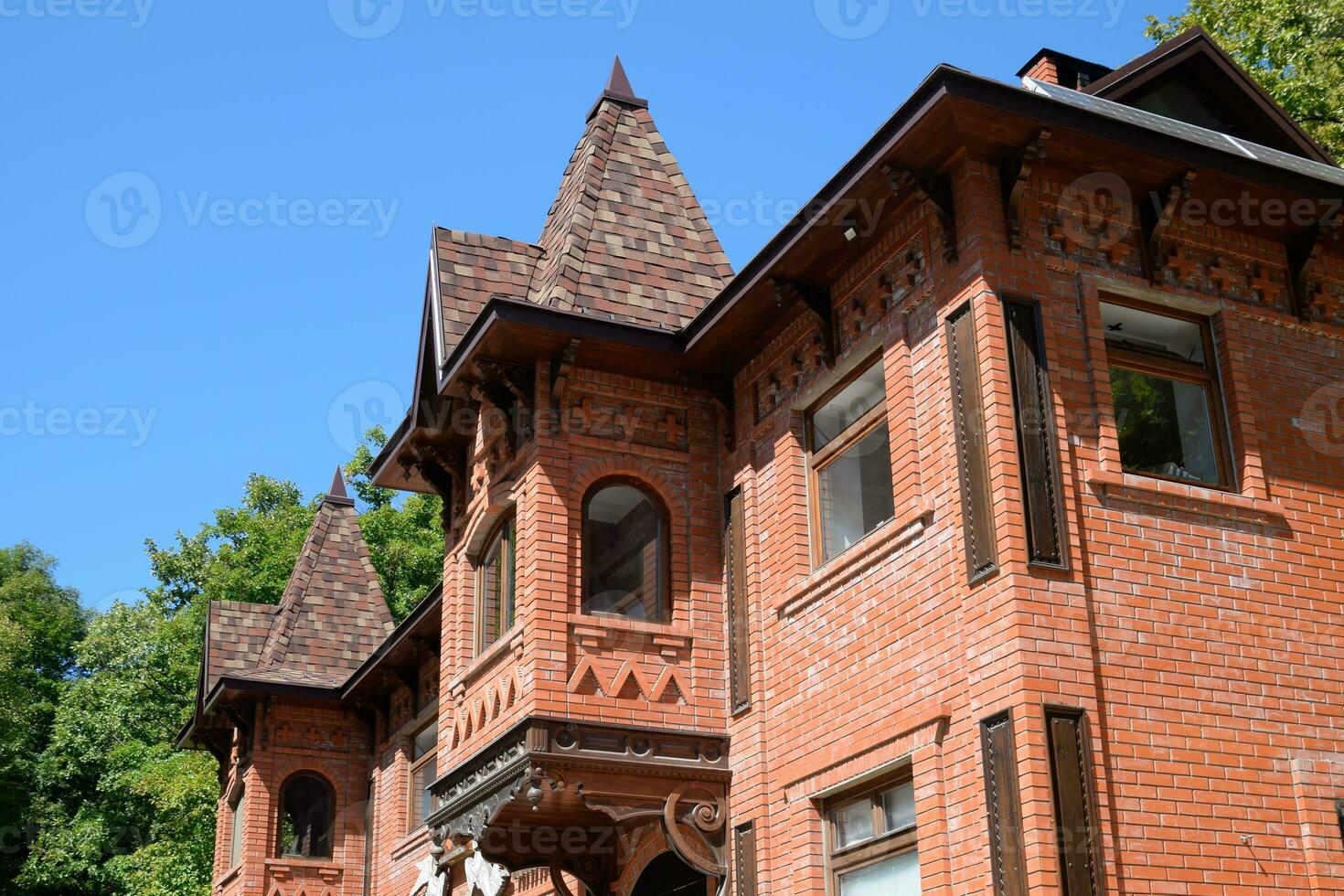 Part of the brick building of red brick and shingles on the roof photo