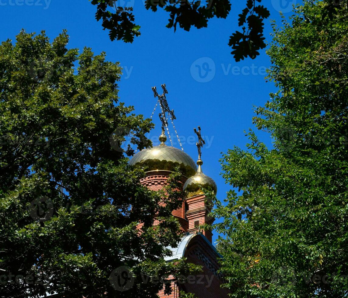 Hazme de el ortodoxo Iglesia con cruces, ver mediante el ramas de arboles en contra el azul cielo foto