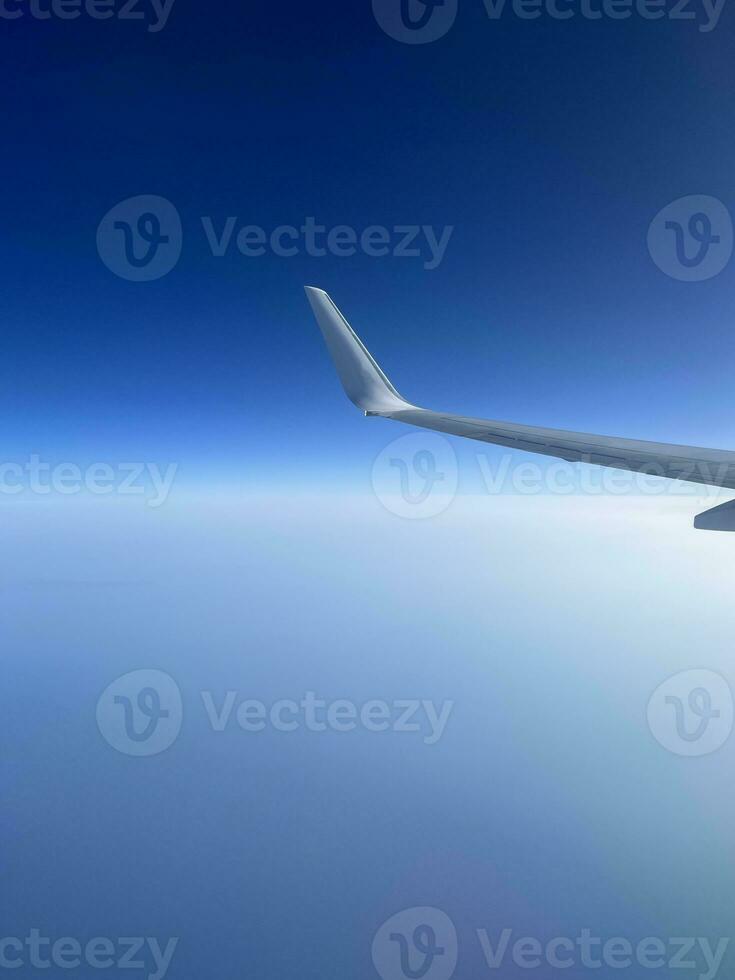 View from the airplane window. Beautiful cloudscape with blue sky. Wonderful panorama above white clouds as seen through window of an plane. photo