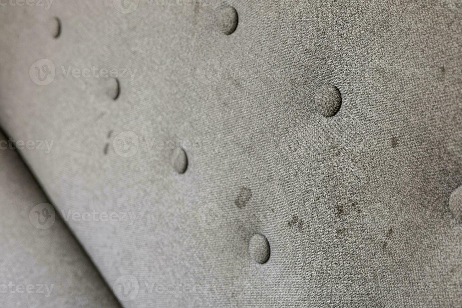 Dirty sofa, close up view. Stains on home textile. Upholstered furniture cleaning concept. Dirty couch, chemnical cleaning needed. Dirt, mess. Care of home fabrics. photo