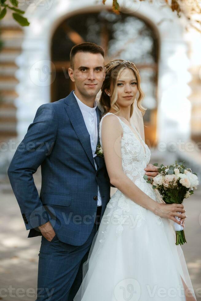 recién casados caminar en el ciudad cerca antiguo edificios foto