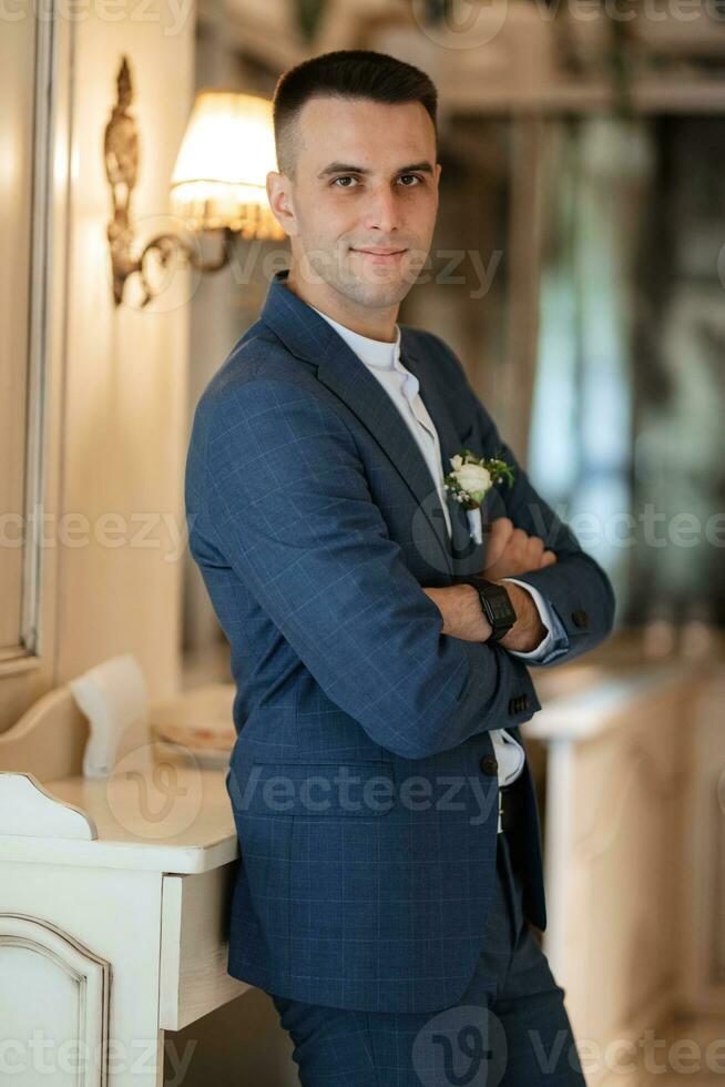 portrait of a groom in a gray plaid suit with a tie in a light bar photo