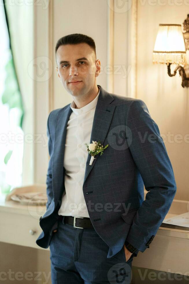 retrato de un novio en un gris tartán traje con un Corbata en un ligero bar foto