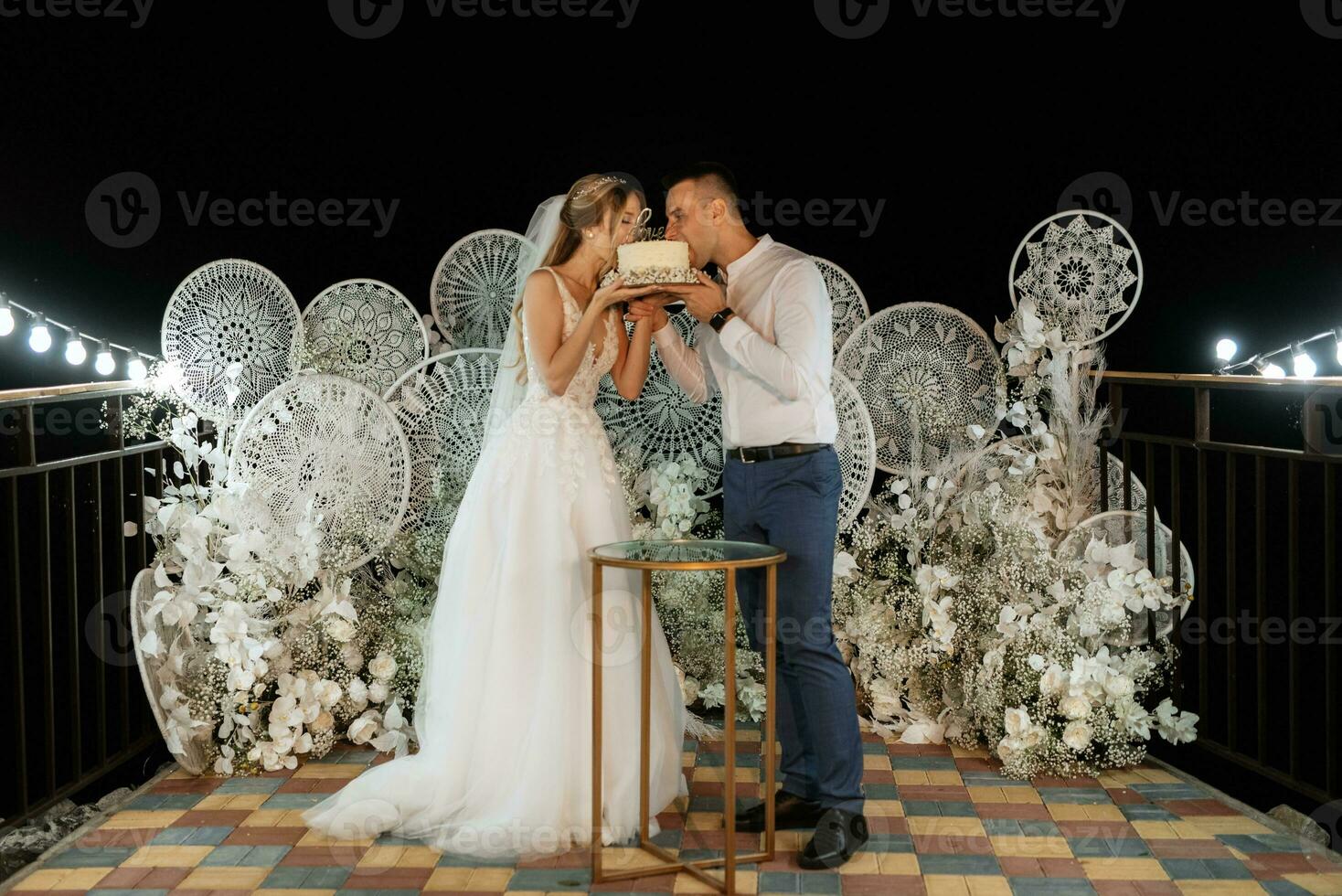 los recién casados felizmente cortan y prueban el pastel de bodas foto