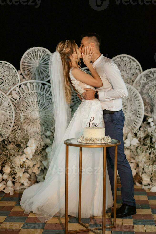 newlyweds happily cut and taste the wedding cake photo