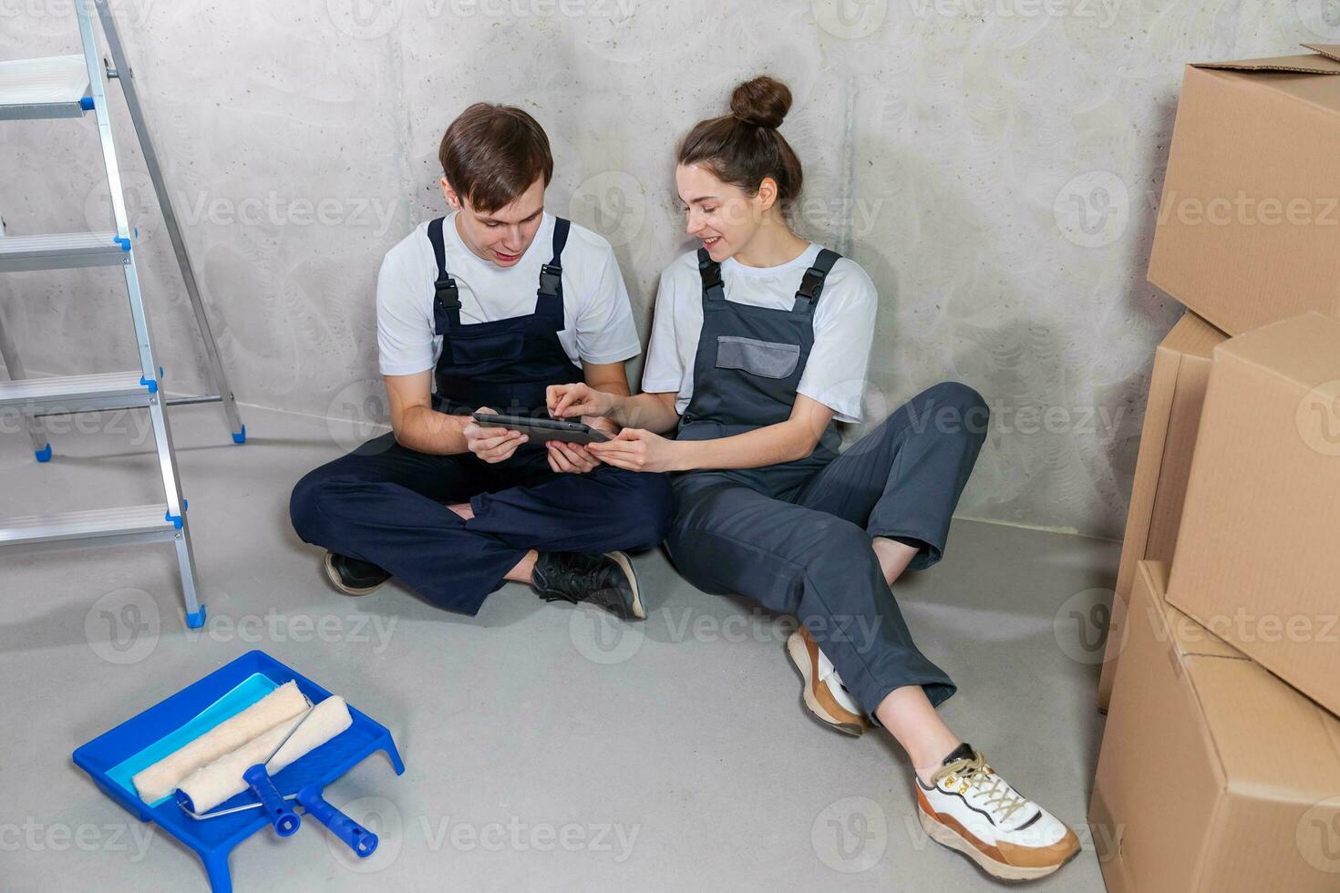 Couple in new home during repair works discussing about home design project looking repair plan on tablet. Happy family choosing new decorations and design. Home renovation DIY renew makeover concept. photo