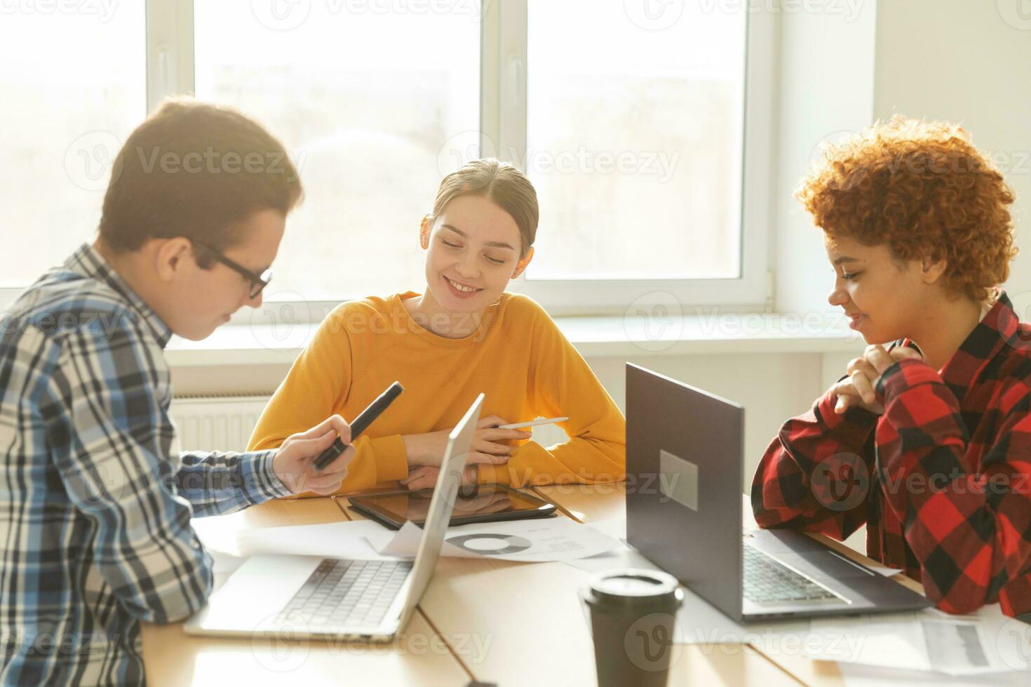Teamwork brainstorm. Diverse colleagues working together discuss financial statistics. Group of happy young modern people sitting in creative office discussing business. Young professional team. photo
