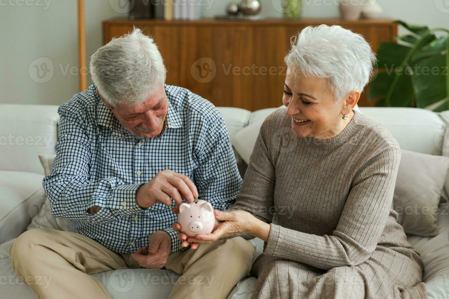 Saving money investment for future. Senior adult mature couple holding piggy bank putting money coin. Old man woman counting saving money planning retirement budget. Saving investment banking concept. photo