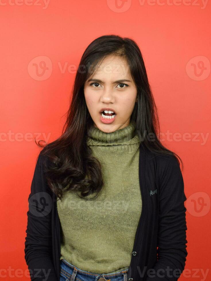 Shouting and Angry Gesture Of Beautiful Asian Woman Isolated On Red Background photo