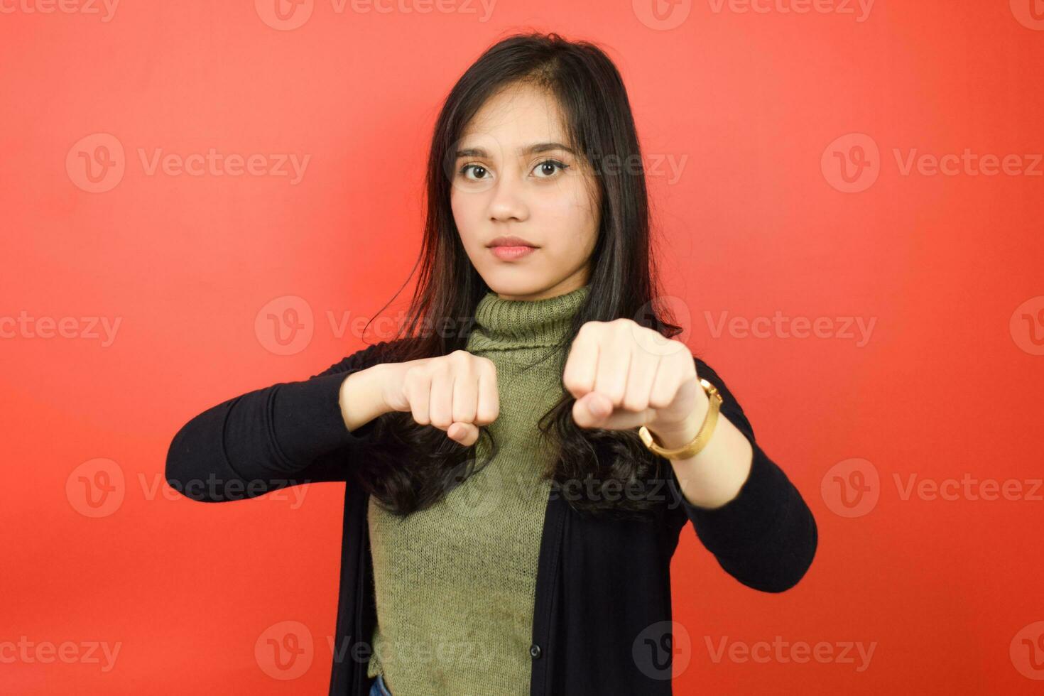 puñetazos puño a lucha o enojado de hermosa asiático mujer aislado en rojo antecedentes foto