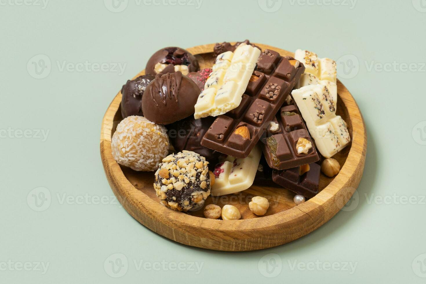 Wooden plate with healthy craft natural candies and mini chocolates. Sweet food, healthy dessert photo