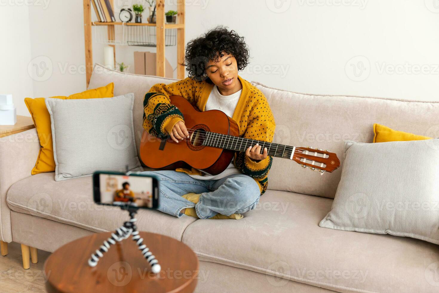Blogger guitarist. Happy african american girl blogger playing guitar singing song recording vlog. Social media influencer woman streaming recording at home studio. Music content creator broadcast. photo