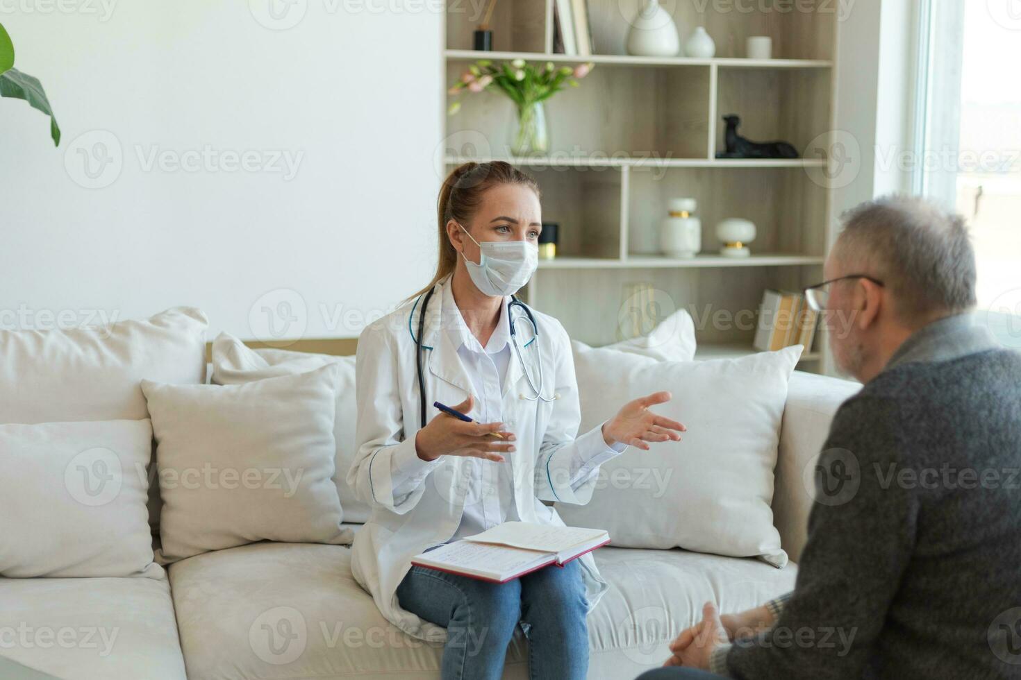 Female doctor examining older senior man in doctor office or at home. Old man patient and doctor have consultation in hospital room. Medicine healthcare medical checkup. Visit to doctor. photo