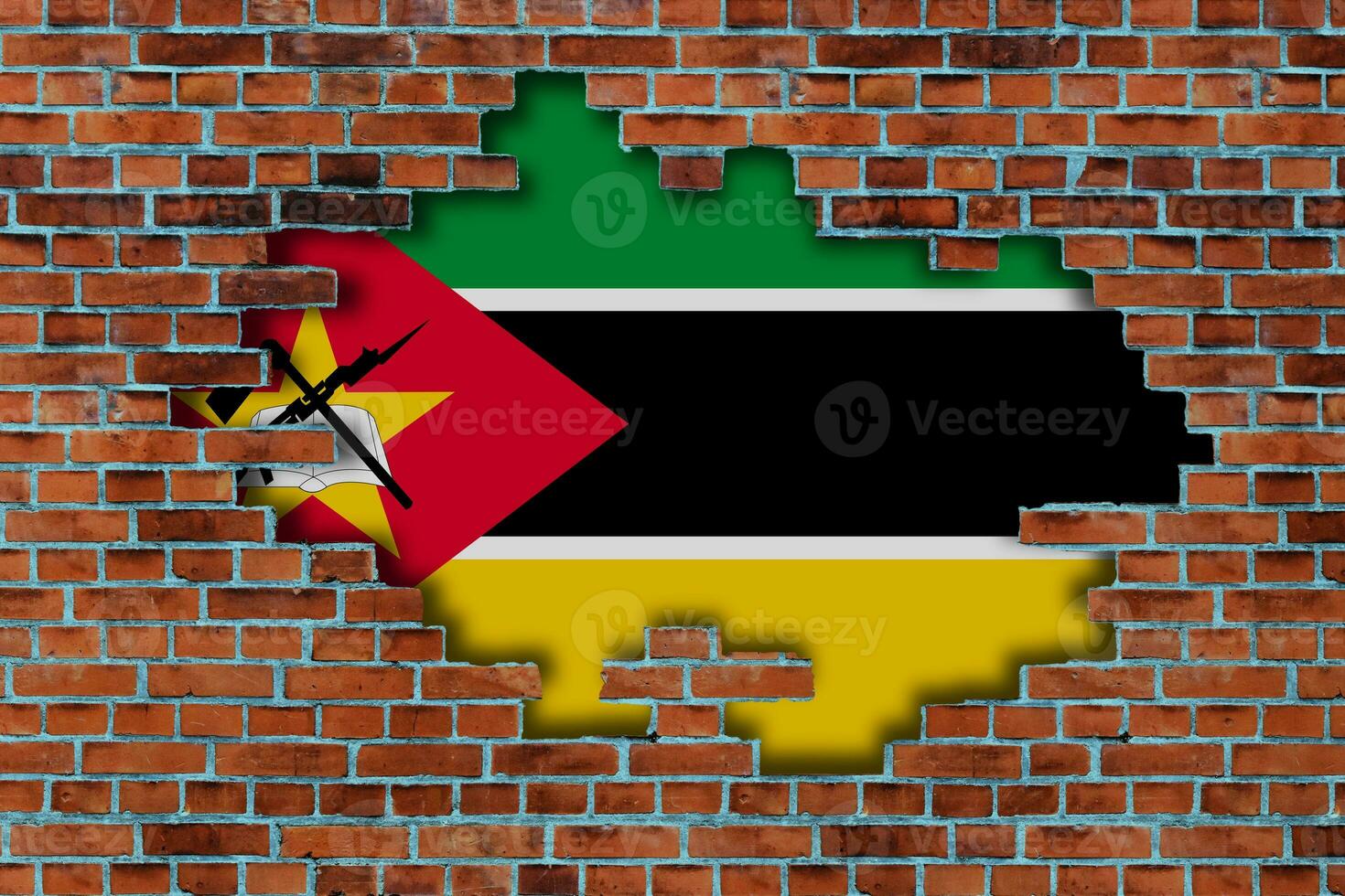 3D Flag of Mozambique behind the broken old stone wall background. photo