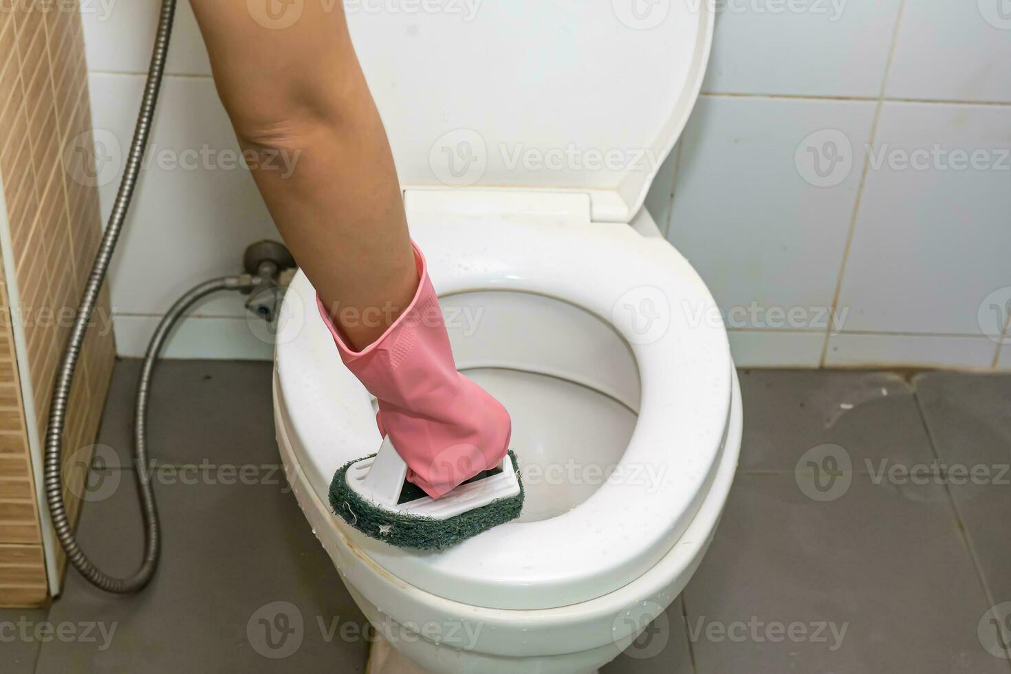 Woman cleaning toilet photo