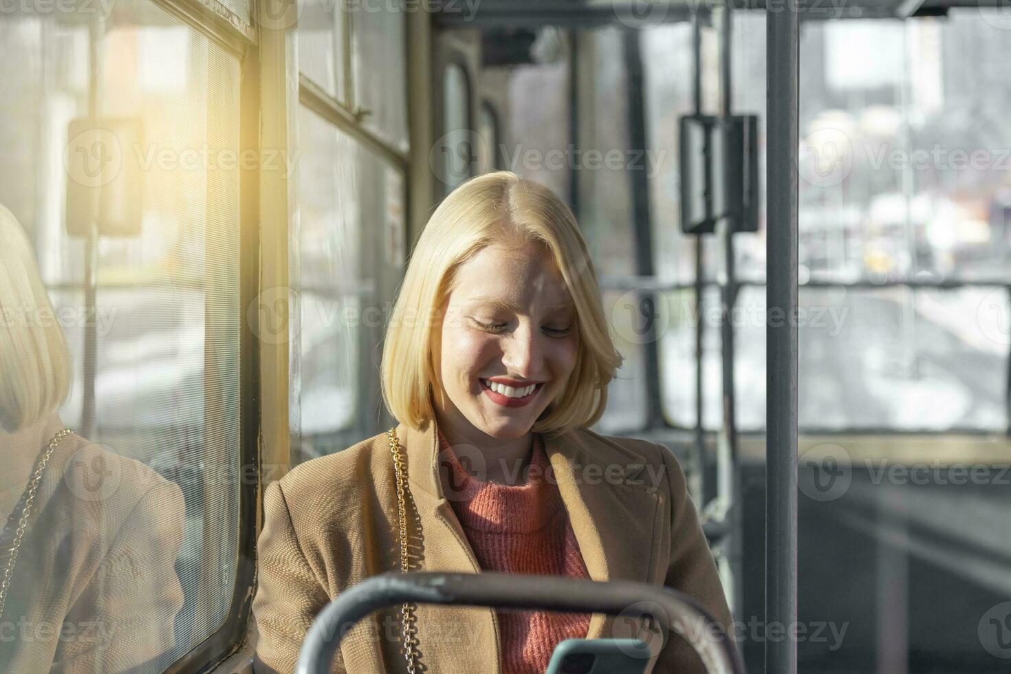 people in public transport, commuters, woman passenger looking at the screen of her smartphone photo
