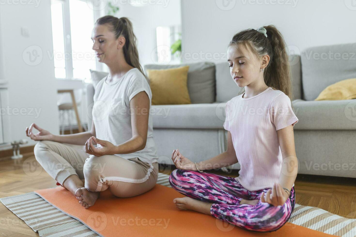 alegre joven mujer y pequeño niña en ropa de deporte hacer ejercicio juntos  en moderno ligero habitación. madre y hija practicando yoga 25888036 Foto  de stock en Vecteezy