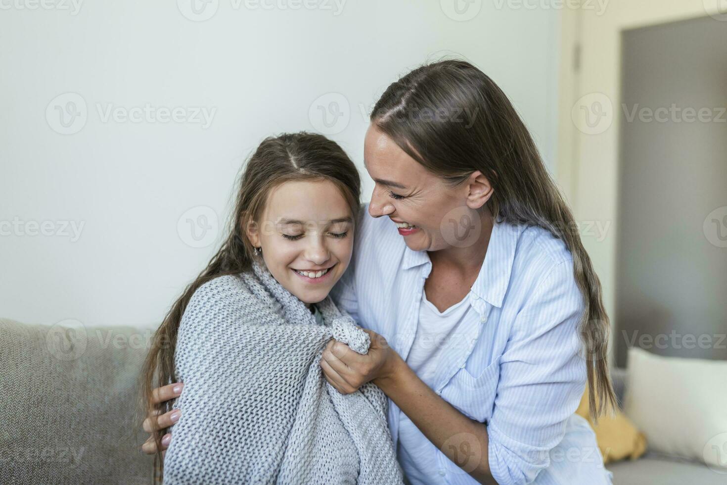 cuidando joven madre poniendo un Saco en su hija a hogar. bueno hora a hogar. niño despierta arriba desde dormir. familia jugando debajo cobija en el cama en el dormitorio. foto