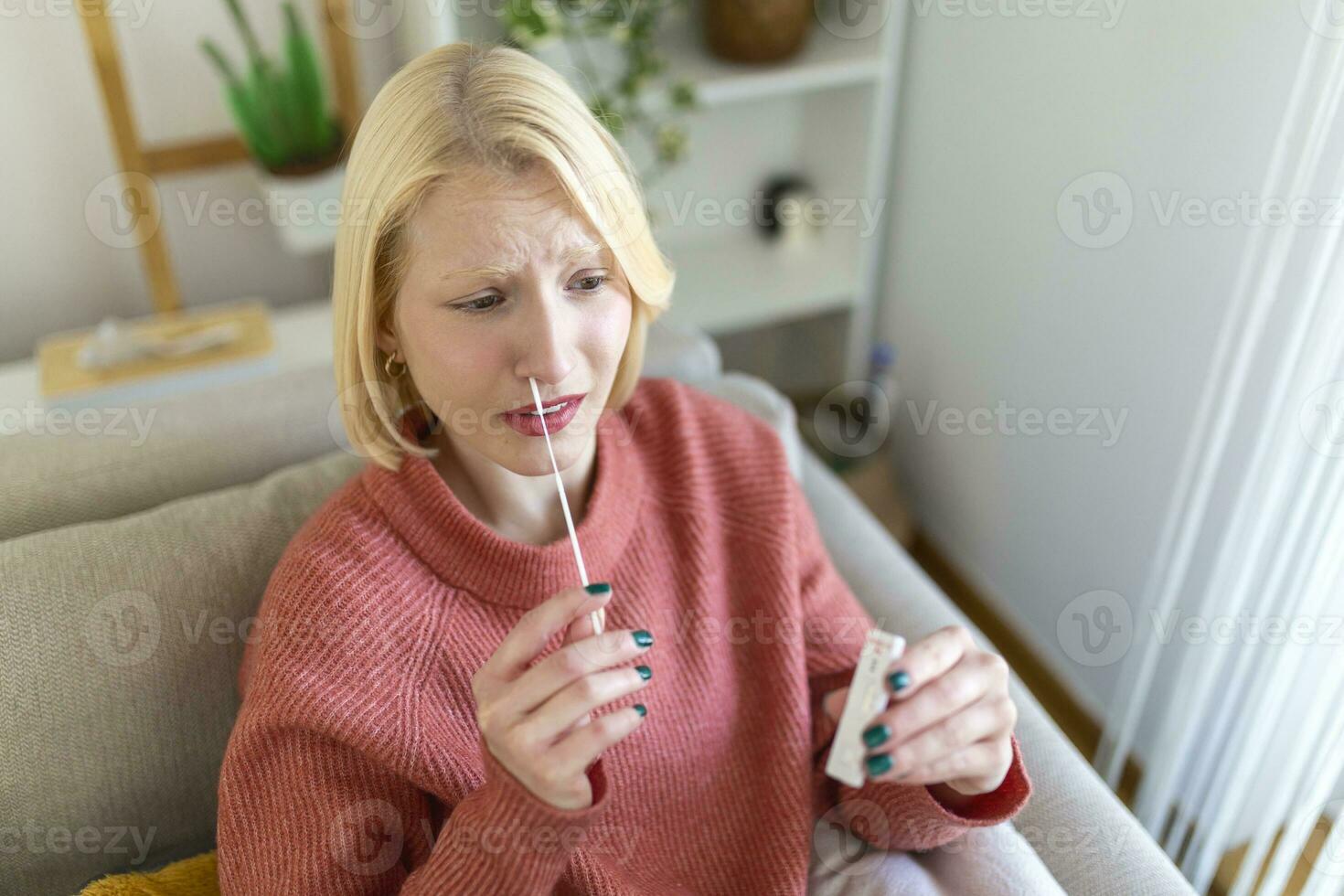 Young woman holding self testing self-administrated swab and medical tube for Coronavirus covid-19, before being self tested at home photo
