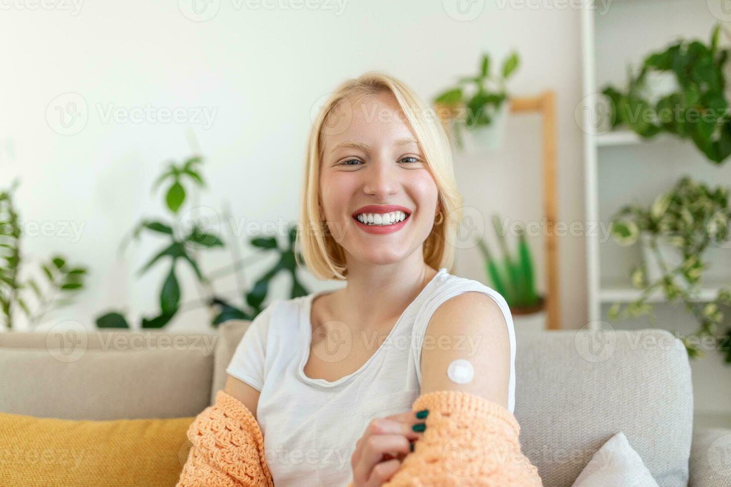 Young woman with adhesive bandage on her arm after Corona virus vaccine. First aid. Medical, pharmacy and healthcare concept. photo