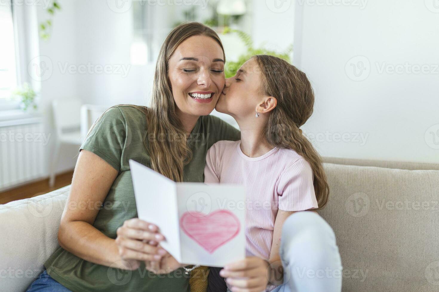 Happy mother's day. Child daughter congratulates mom and gives her postcard. Mum and girl smiling and hugging. Family holiday and togetherness. photo