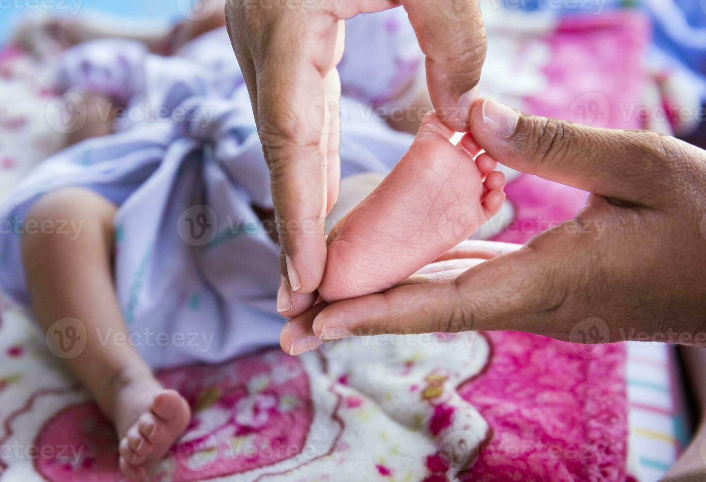 Newborn baby feet in female hands shaped like a cute heart. 25889463