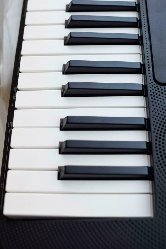 de cerca de piano llaves. piano negro y blanco llaves y piano teclado musical instrumento metido a el hogar balcón durante soleado día. foto