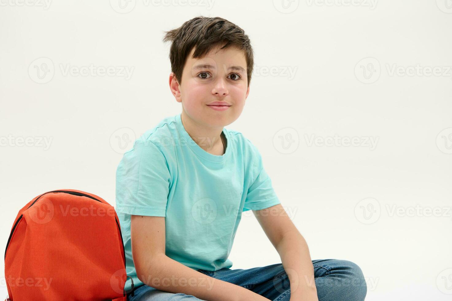 Close-up studio portrait of a smart teenage school boy, looking at camera, isolated background. Back to school concept photo