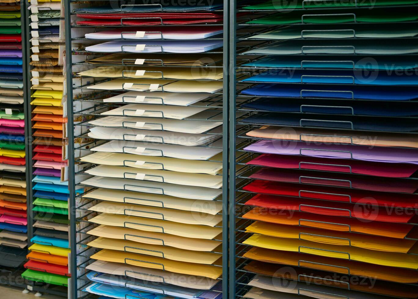 Stand with various color paper on shelves, for art, design, watercolor painting and pastel drawing, in stationery shop. photo