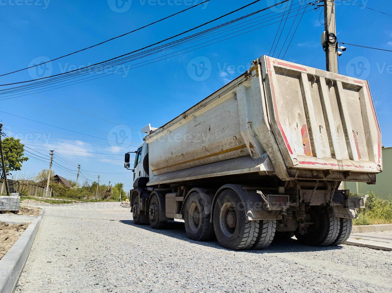 A truck carrying construction sand or concrete. The concept of reloading on the roads and renting a dump truck for work photo