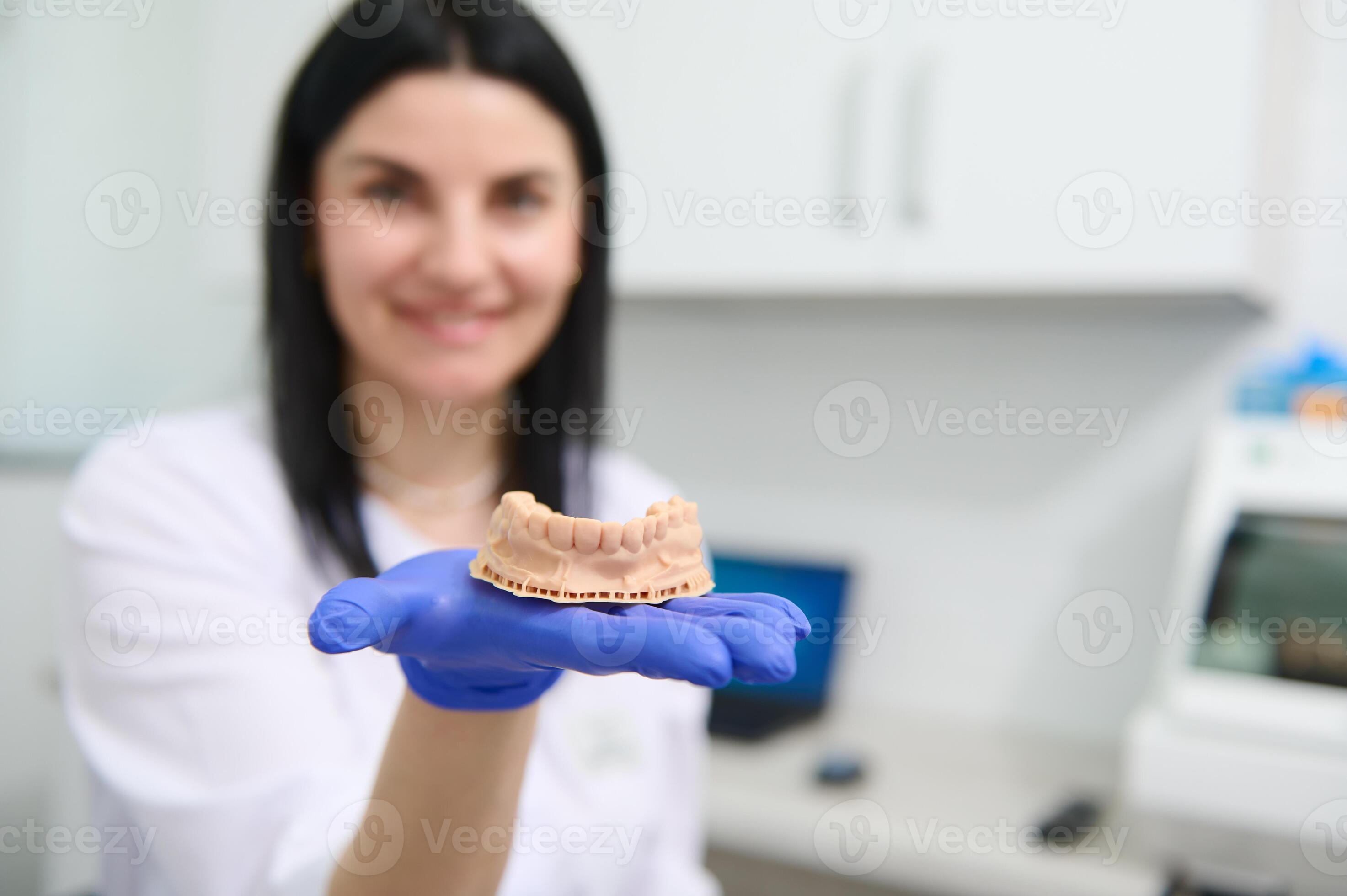 Details gypsum mold of the human lower jaw in the hand of a blurred