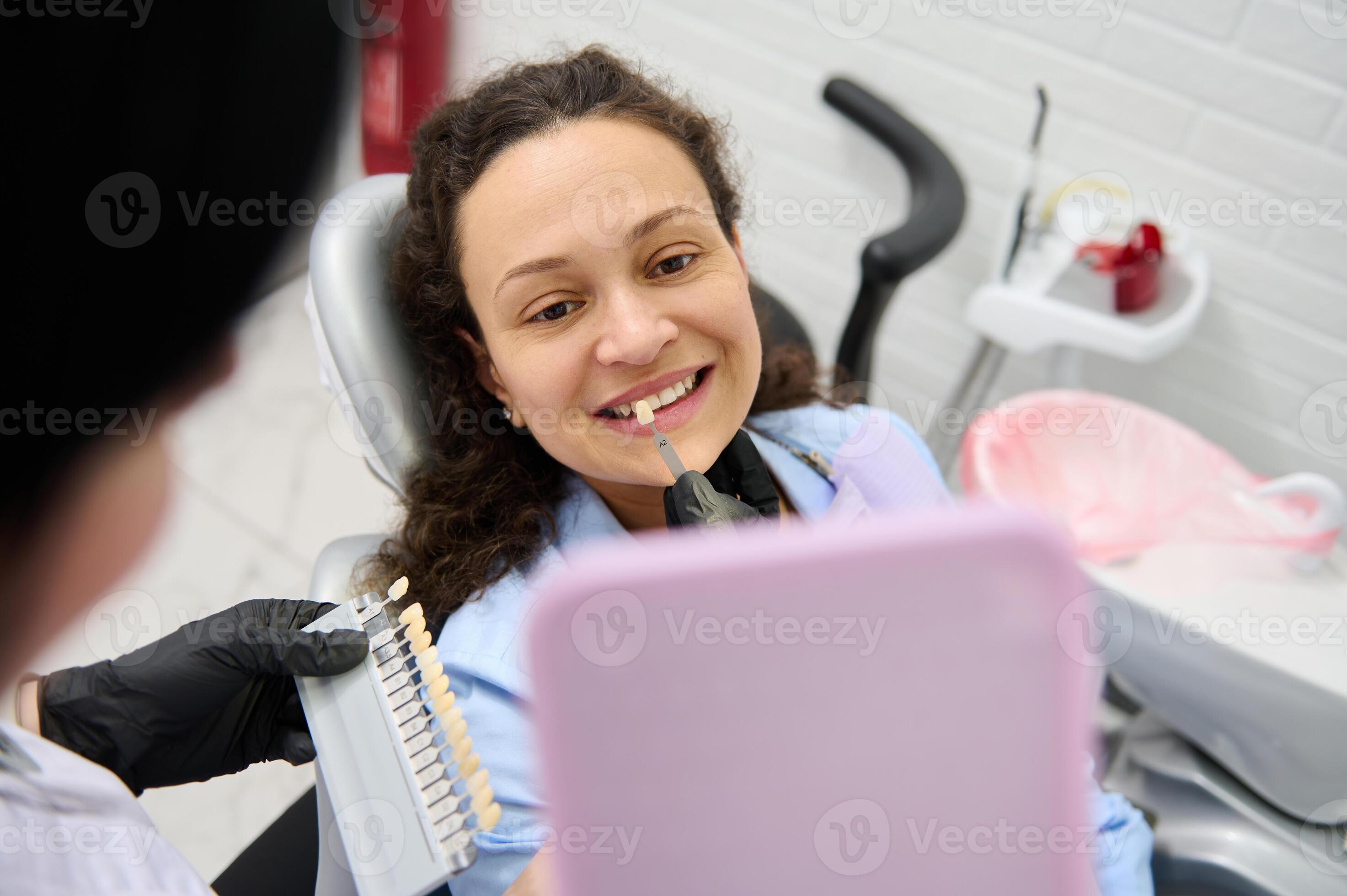 Dentist helps a woman patient pick teeth whitening shade from the chart