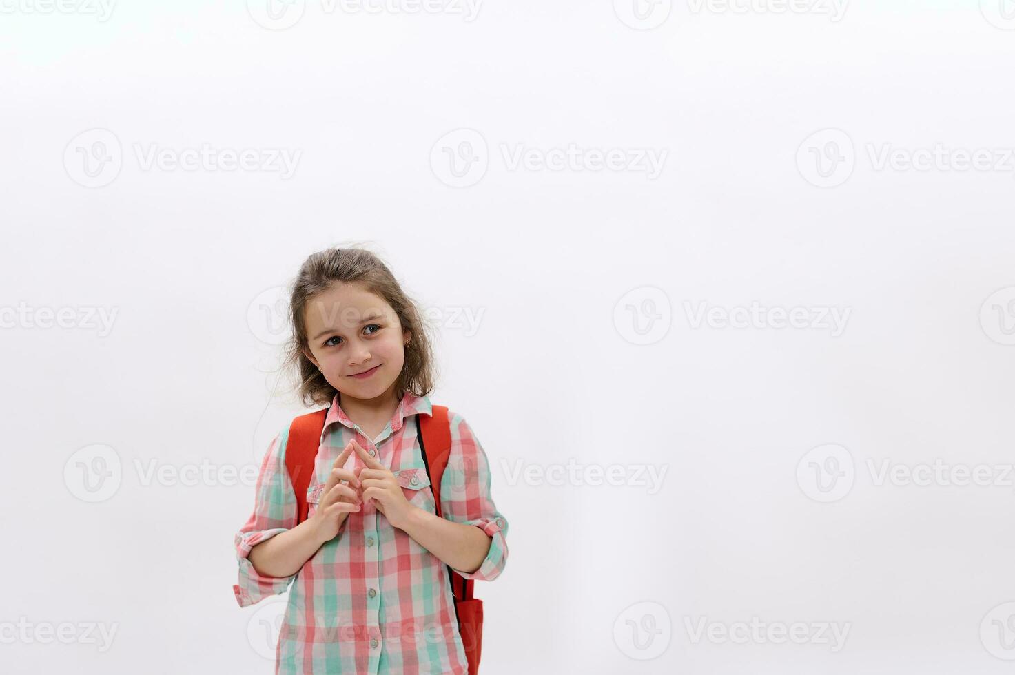 hermosa preescolar pequeño niña con mochila, lindo sonriente mirando aparte un Copiar espacio en blanco aislado antecedentes foto