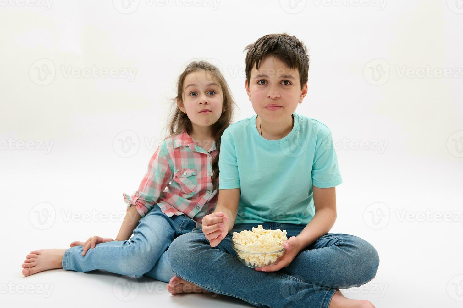 adorable niños, pre adolescente chico y pequeño niña comiendo Palomitas, acecho película o dibujos animados, blanco antecedentes. familia ocios foto