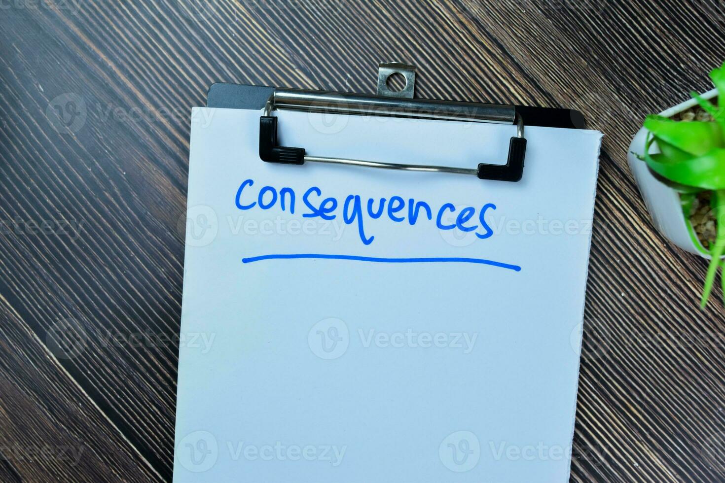 Concept of Consequences write on paperwork isolated on Wooden Table. photo