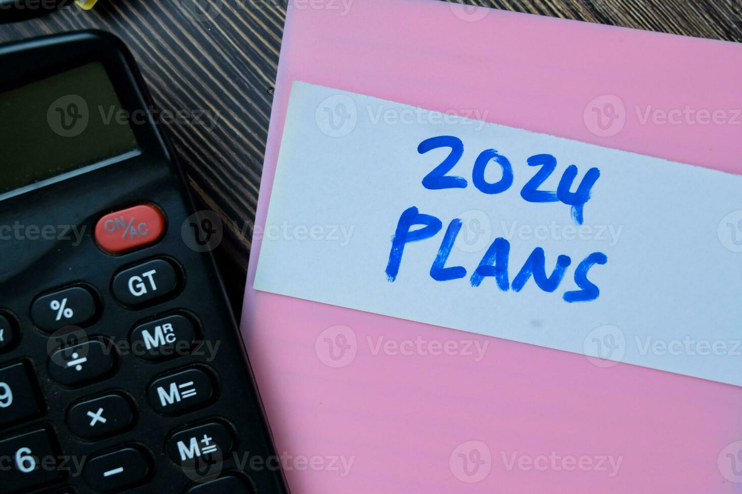 Concept of Plans 2024 write on sticky notes isolated on Wooden Table. photo