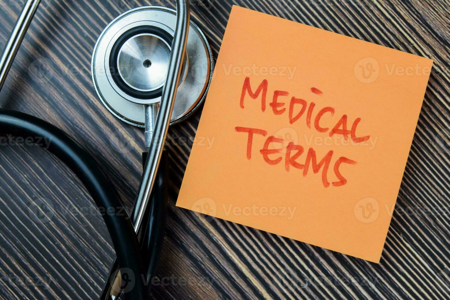 Concept of Medical Terms write on sticky notes with stethoscope isolated on Wooden Table. photo