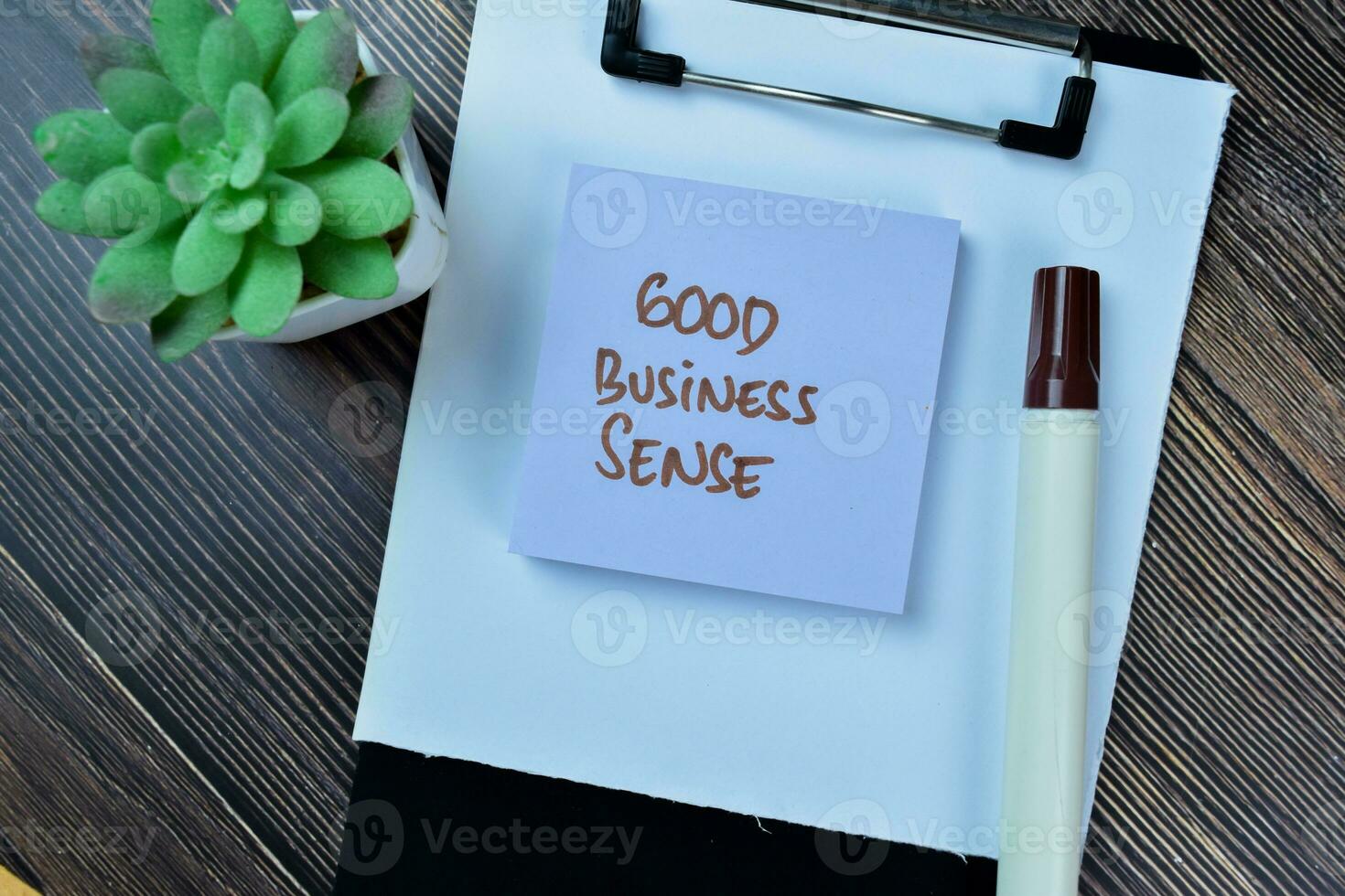 Concept of Good Business Sense write on sticky notes isolated on Wooden Table. photo