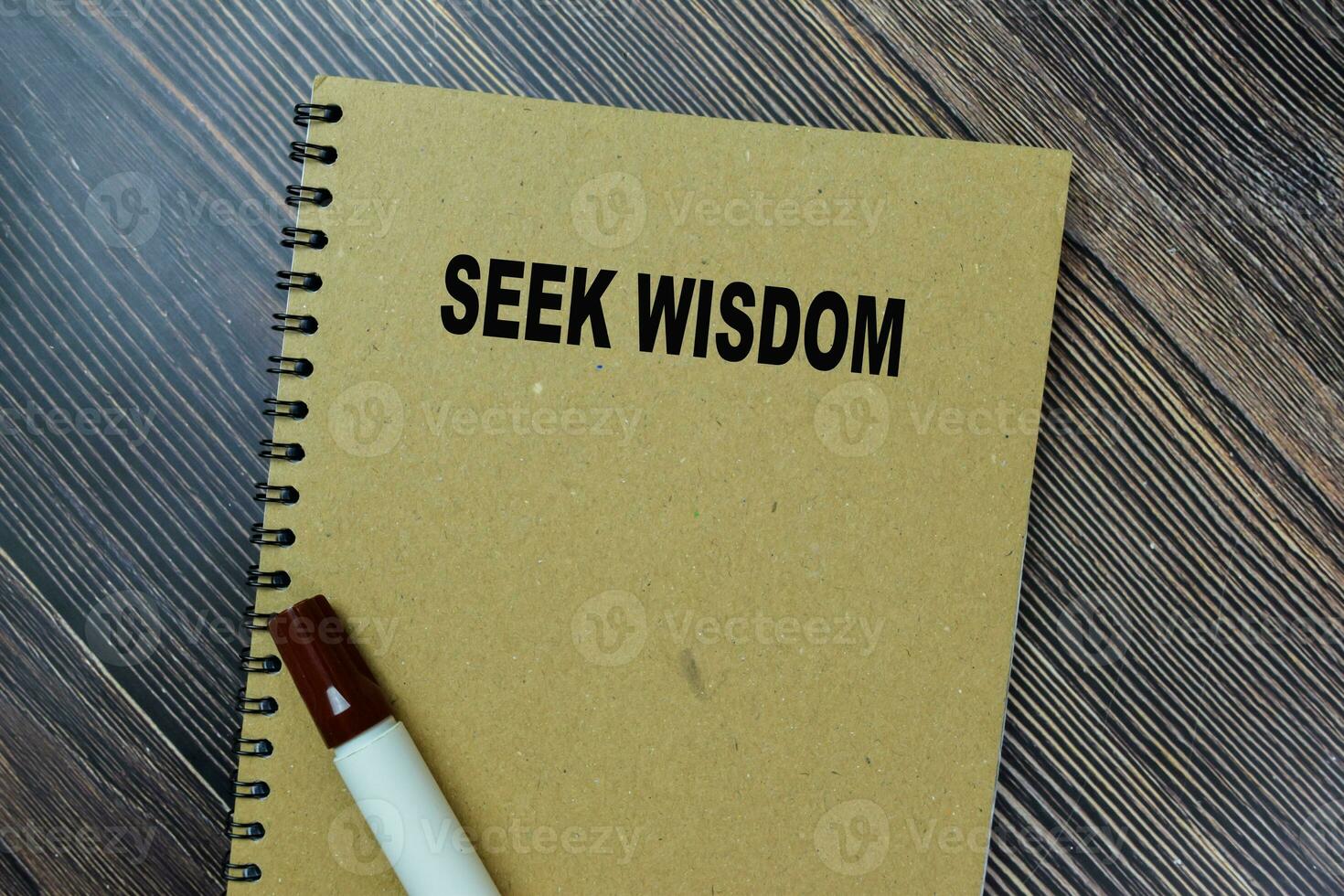 Concept of Seek Wisdom write on sticky notes isolated on Wooden Table. photo