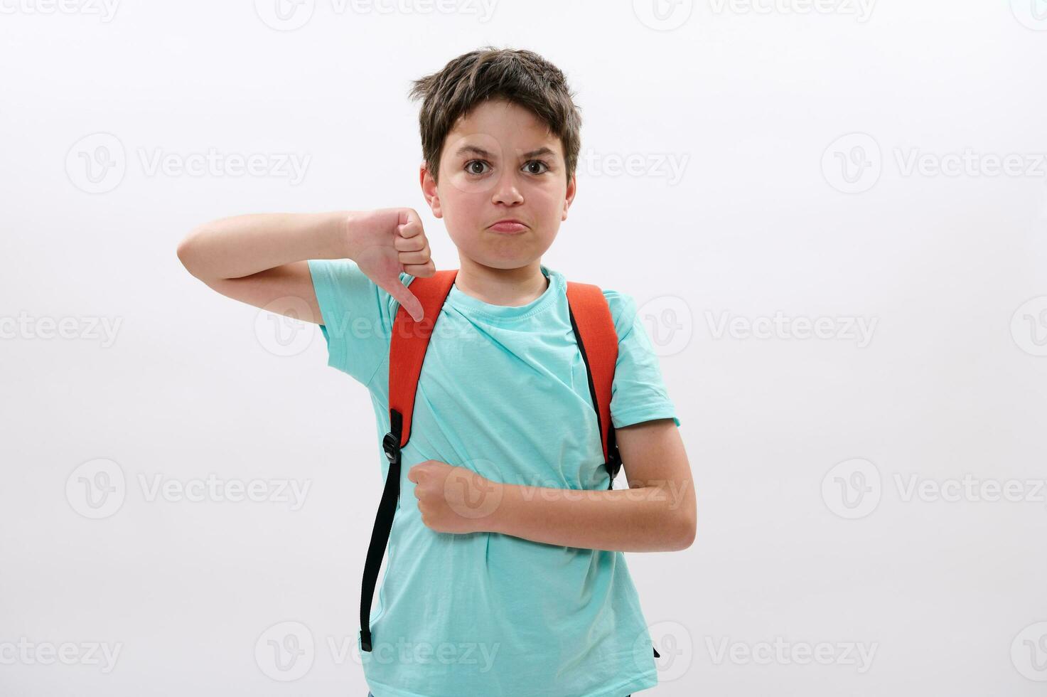 Schoolboy thumbs down at camera, suffers from act of bullying at school, education difficulties, psychological problems photo