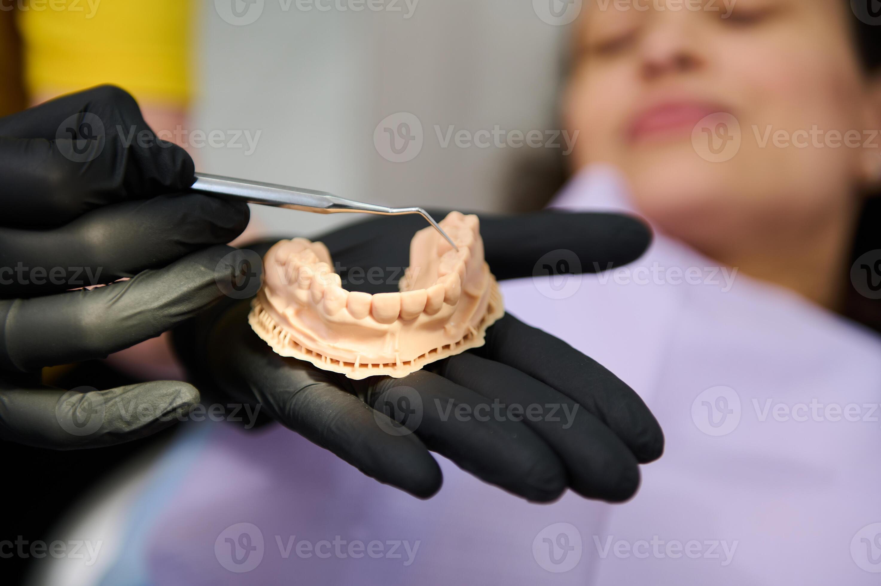 Dentist shows dental plaster mold to camera, holding hands above a