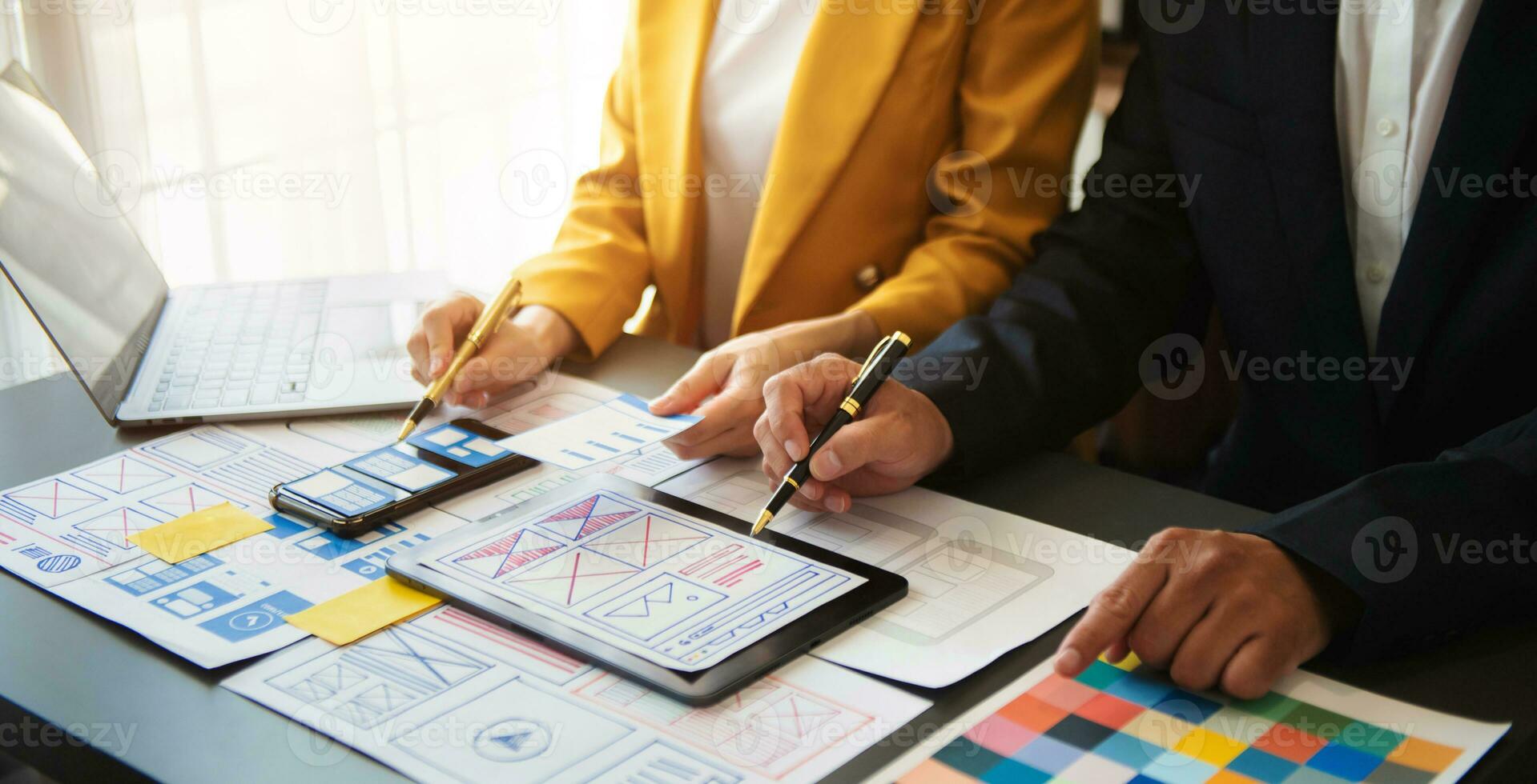 UX developer and ui designer brainstorming about mobile app interface wireframe design with customer breif and color code at office. photo