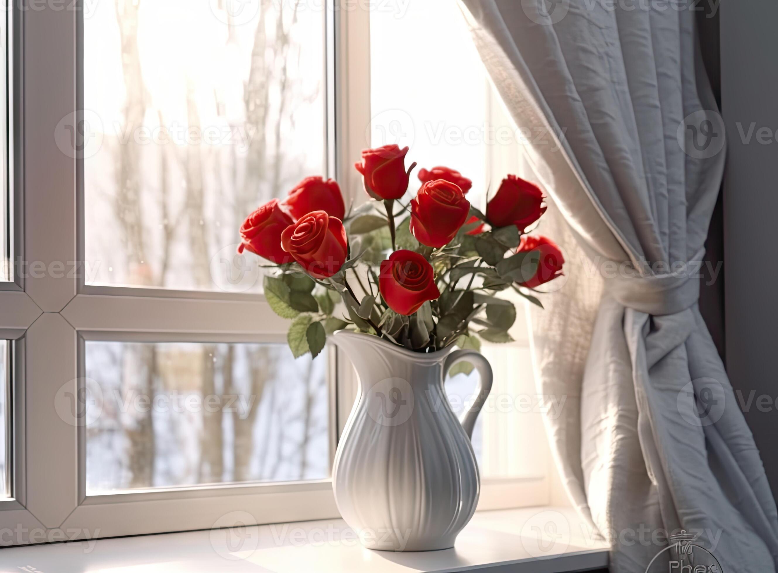 Beautiful large red roses in a glass vase on a window in the living